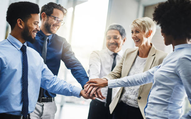 Cropped shot of a group of businesspeople putting their hands together in unity